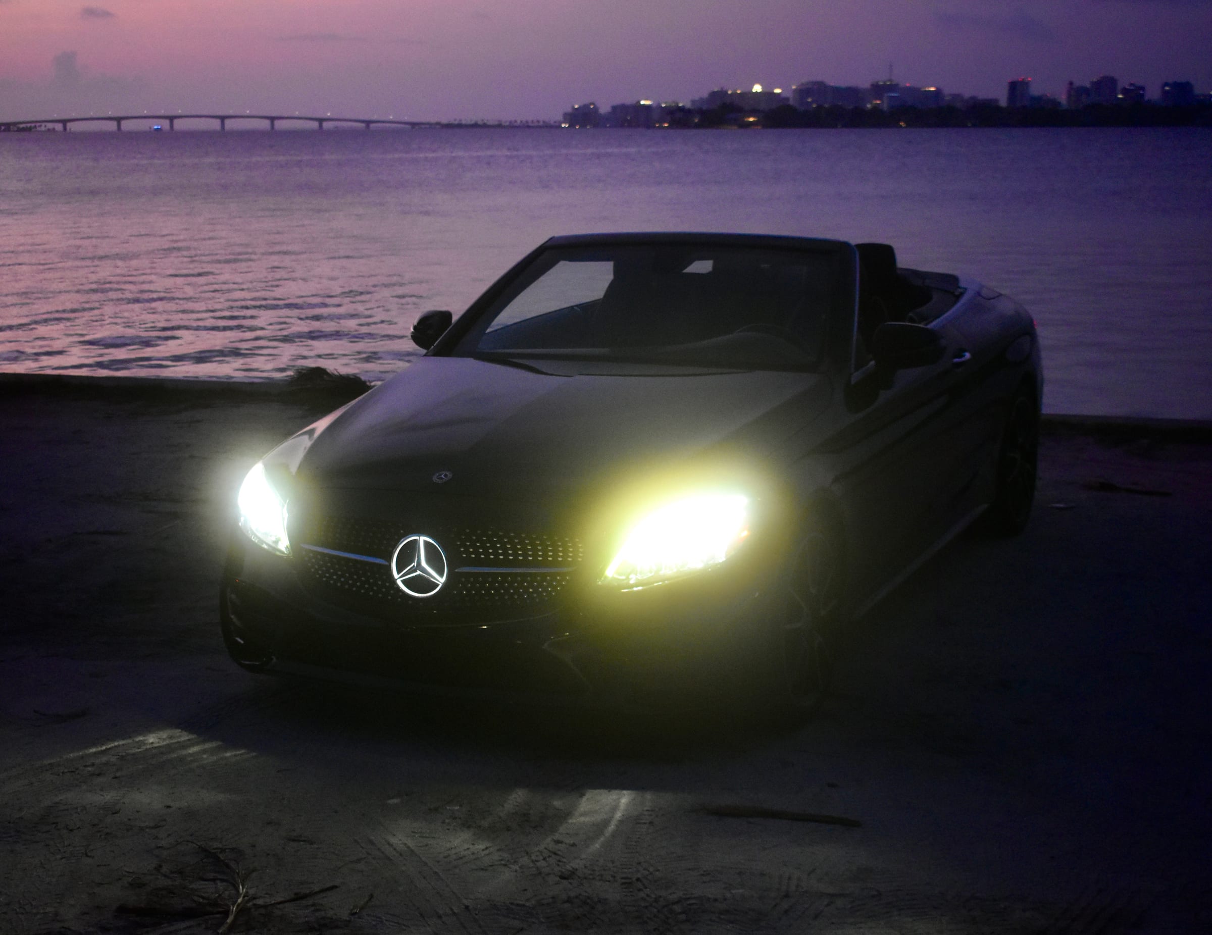 Black Mercedes-Benz C300 Cabriolet overlooking the water at twilight